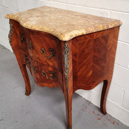 A timeless and compact French Louis XV style two drawer Kingwood marquetry inlaid commode. It features a stunning marble marble top and decorative mounts. The compact design of this commode ensures versatility, making it a perfect addition to any living space, bedroom or hallway. It has been sourced directly from France and is in good original detailed condition.