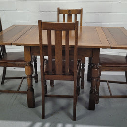 Fabulous small Oak extension table and four dining chairs. The table extends from a four seater to a six seater. The chairs have nice carvings and leather inset seats. They are in original detailed condition.