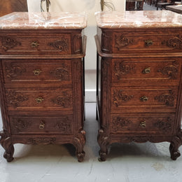 A pair of hard to find French Oak Louis XV style four drawer marble topped bedsides with attractive carvings. They are in good original detailed condition and have been sourced from France.