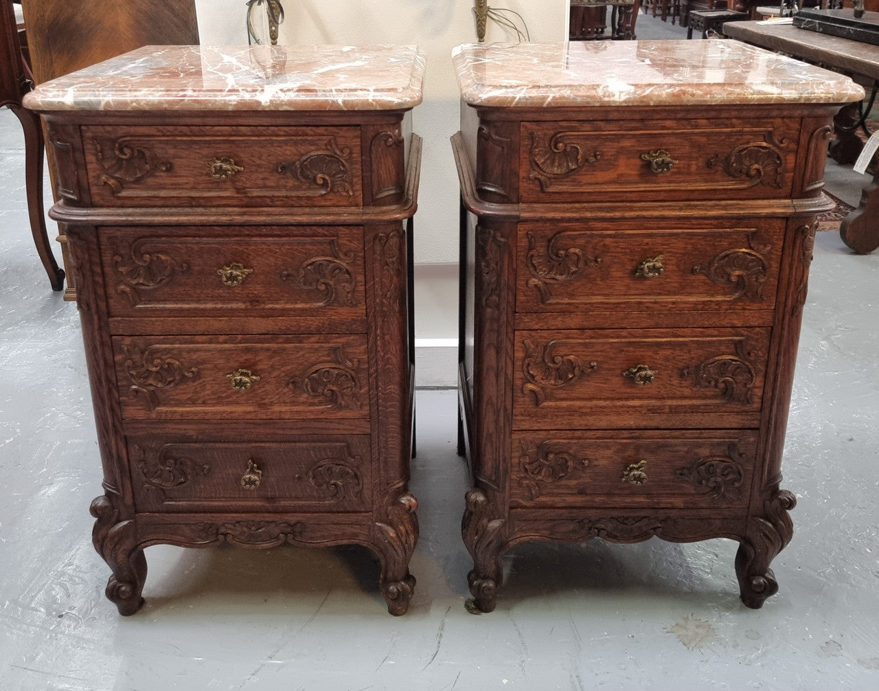 A pair of hard to find French Oak Louis XV style four drawer marble topped bedsides with attractive carvings. They are in good original detailed condition and have been sourced from France.