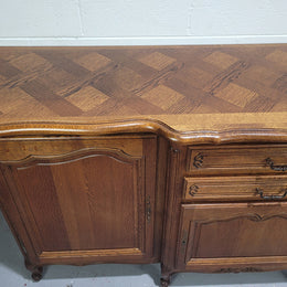French Louis XV style parquetry top three door sideboard with two drawers. Plenty of storage space with a shelf behind each door. It is in good original detailed condition.