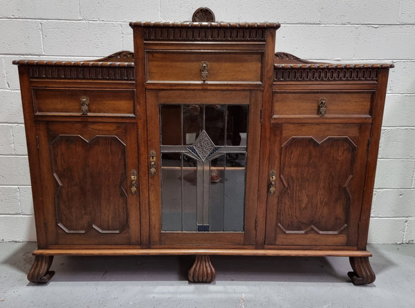 Lovely Oak Tudor style rope edge sideboard with leadlight center door, three drawers and two solid cupboards. In good original condition.