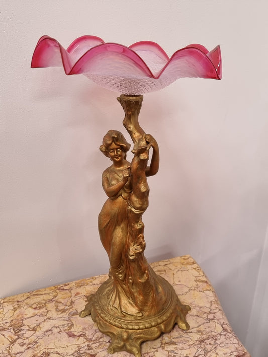 Late Victorian spelter table Centerpiece/comport featuring a woman holding an opalescent and ruby glass bowl. In good original condition with no damage to the ruby bowl.