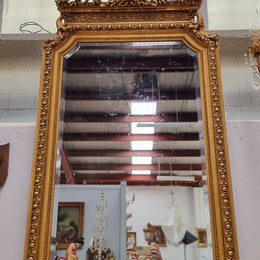 A stunning Napoleon III gilt mantle mirror with its original mirror. The top of the mirror is decorated with a beautiful laurel wreath and detailed decorative carving throughout. It is in good original condition with the bevelled mirror showing natural aging please view photo's.