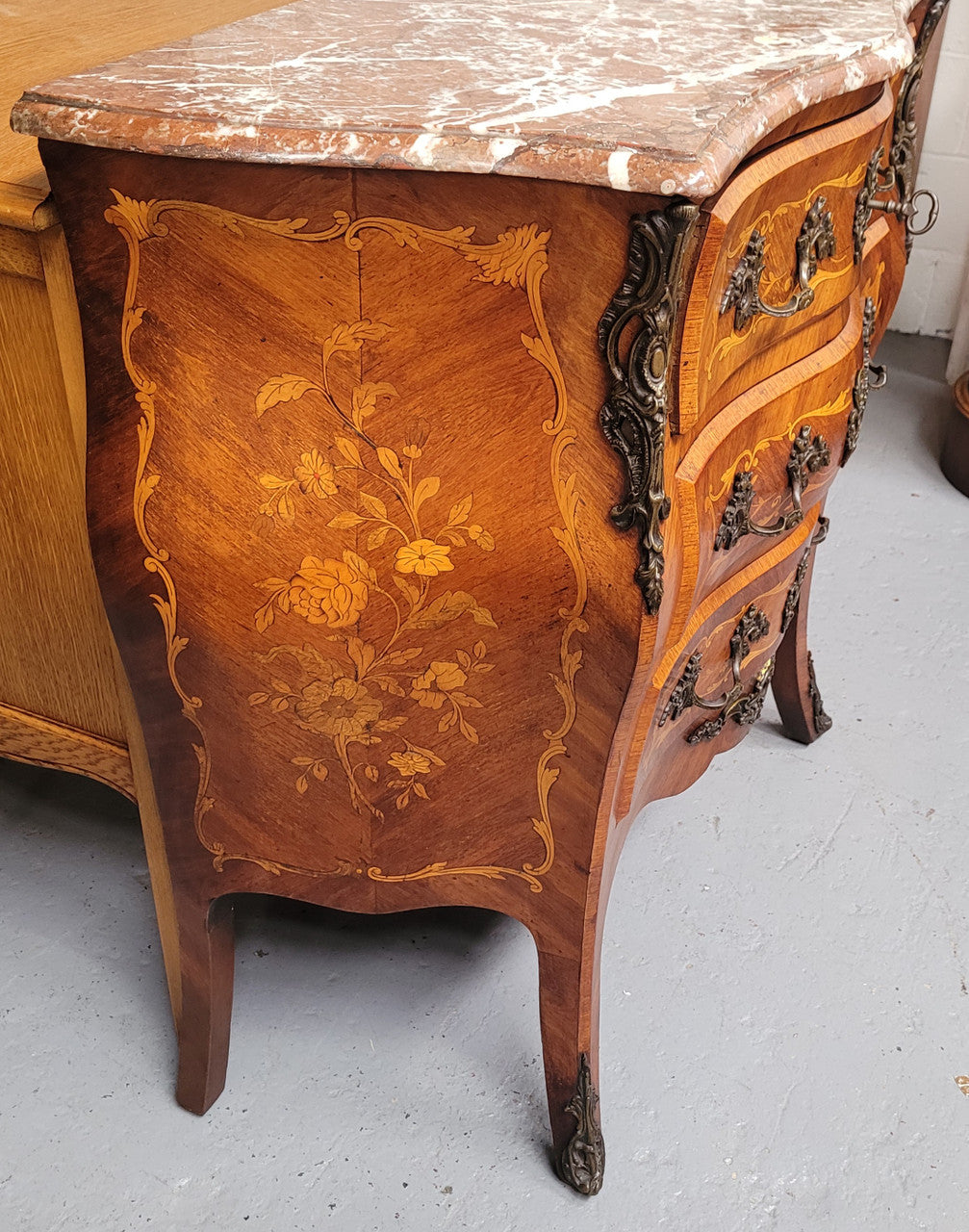 Antique French Louis XV style compact three drawer marble top commode with marquetry inlay and ormolu mounts. Sourced from France and in good original detailed condition.