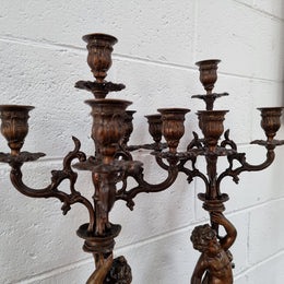 Pair of highly decorative French cherub candelabras with bronzed metal and marble. In good original detailed condition.