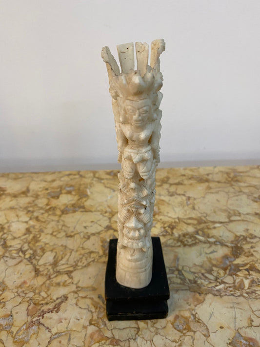 Vintage ornately carved bone ornament on stand.