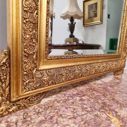 French ornate gilt decorated and floral bevelled mirror. It has been sourced from France and it is in good original condition.