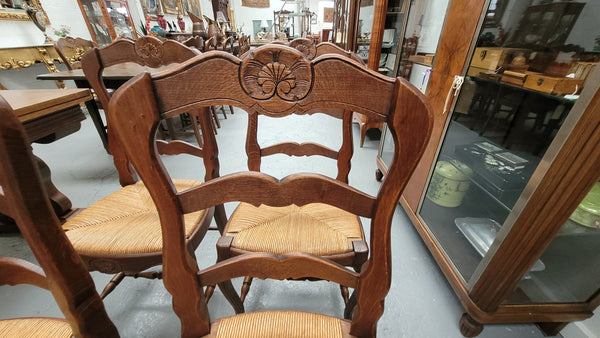 Set of six Louis XV style French Oak rush seat dining chairs. These chairs are very sturdy and have been professionally re-glued to ensure long lasting strength and sturdiness. They are in very good original detailed condition.