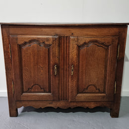 A charming French Oak early 18th Century two door sideboard. Plenty of storage space with two fixed shelves either side. It is in good original detailed condition for its age and comes with  a working key and working locks.