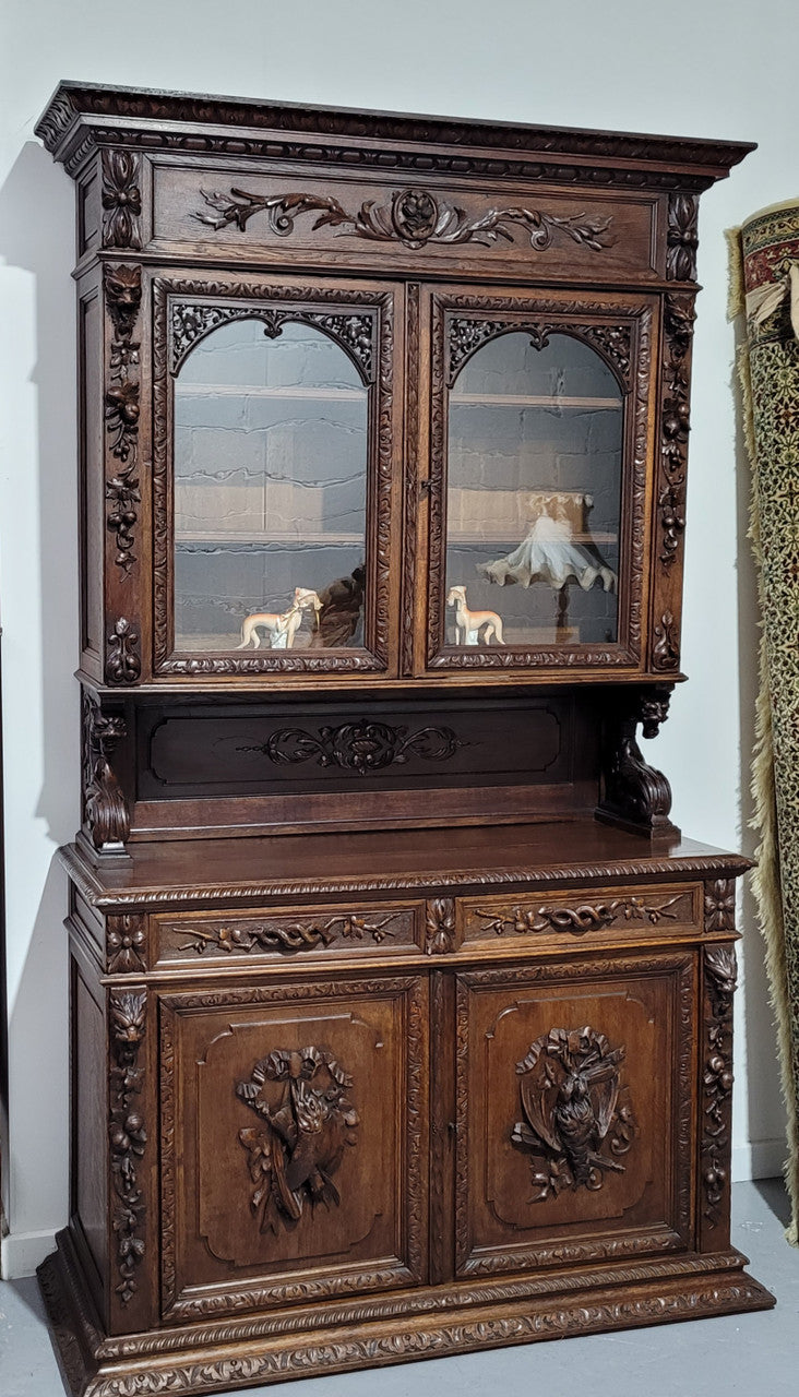 Grand French Oak Gothic style buffet with amazing detailed carvings. This stunning buffet has a display section at the top with two adjustable shelves, two drawers in the middle with elegantly carved handles and storage below with one fixed shelf. It is in good original detailed condition.