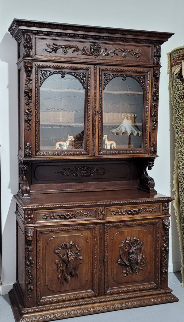 Grand French Oak Gothic style buffet with amazing detailed carvings. This stunning buffet has a display section at the top with two adjustable shelves, two drawers in the middle with elegantly carved handles and storage below with one fixed shelf. It is in good original detailed condition.