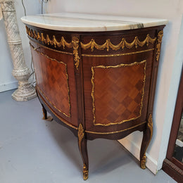 French style marble top two door half-moon buffet with beautiful decorative brass gilt mounts. In good original detailed condition.