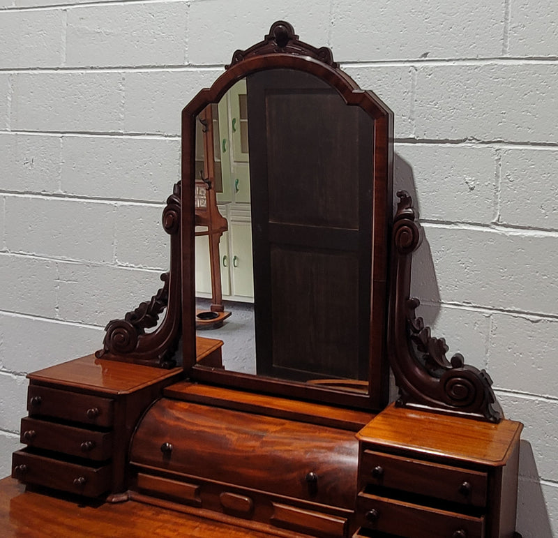 Beautiful Flame Mahogany Victorian duchess dressing table. Circa 1880 in date. It has a serpentine front outline and has an adjustable swing frame mirror. It is fitted with a central roll up storage section and then has three small drawers to either side, aswell as a central drawer in the middle of the serpentine front. It is in good original condition.