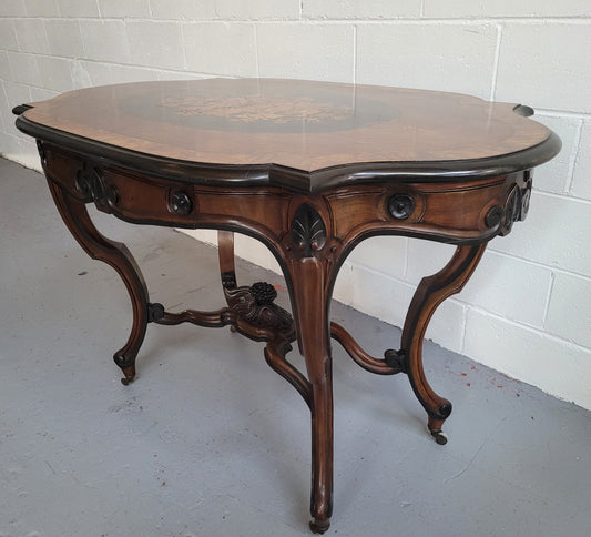 French Napoleon III style center table. Made from Rosewood and figured Walnut and is beautifully inlaid with an ebonized edge.  It has an attractive carved undercarriage and single drawer. In good original detailed condition.