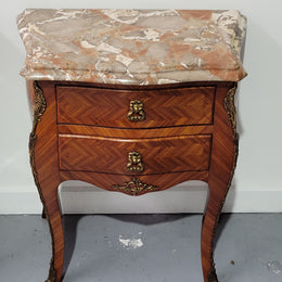 Pair of Louis XV commode style two drawer bedsides with beautiful marble tops and decorative mounts. They are a rare size and are in good, detailed condition.