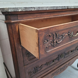 French Oak Louis XV style marble top chest of three drawers. It has beautiful carvings on the drawers with lovely decorative handles all toped with a stunning black and white marble top. In good original detailed condition.