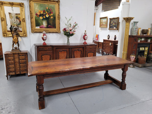 Charming solid rustic Oak stretcher base Farmhouse table. The table is circa 1950's and was custom made using reclaimed oak. It comfortable sits eight and could seat 10. It is in good original detailed condition.