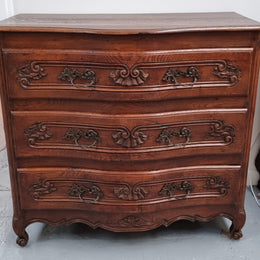 Antique French beautifully carved dark Oak commode with three drawers and ornate handles. It is in good original detailed condition.