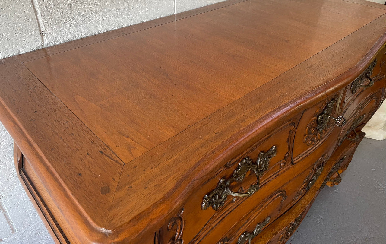 French Walnut Louis XV style five drawer commode. It has a beautiful wooden top and is beautifully carved. It is in good original detailed condition.