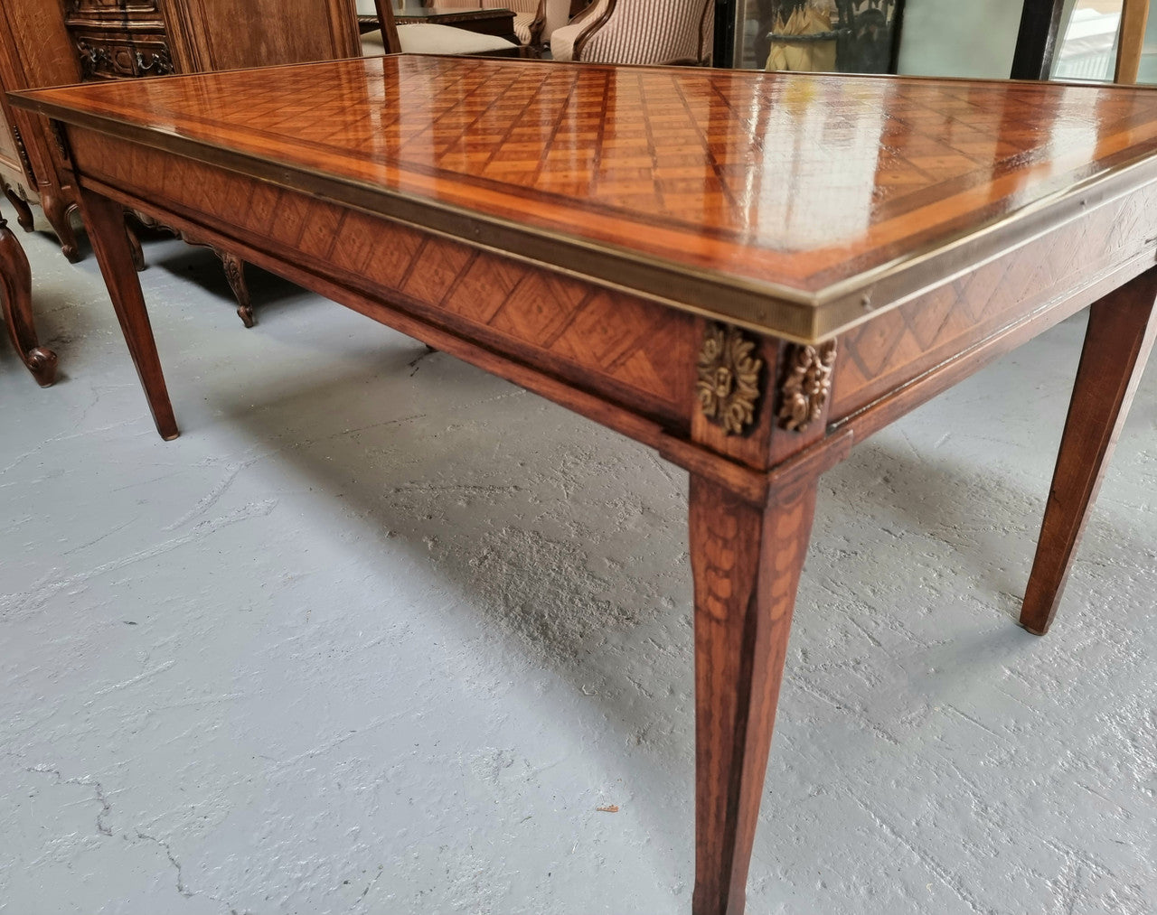 Beautiful French Louis XVI style inlaid coffee table with a brass band and glass top. In good original detailed condition.