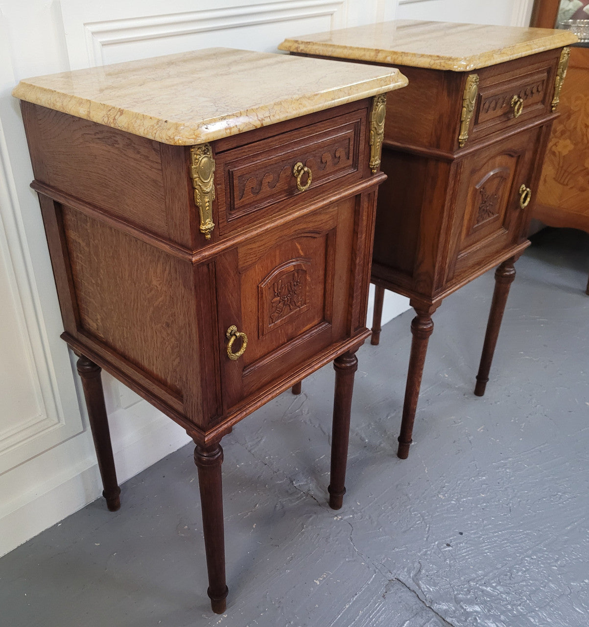 French Oak pair of Louis 16th style marble top bedsides with stunning bronze mounts. They have been sourced from France and are in good original detailed condition.
