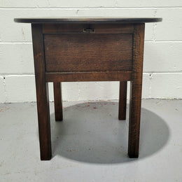 Fabulous round oak side table which also has a hidden sewing box underneath with lovely original blue satin lining and Includes pictured sewing items. It is in good original condition.
