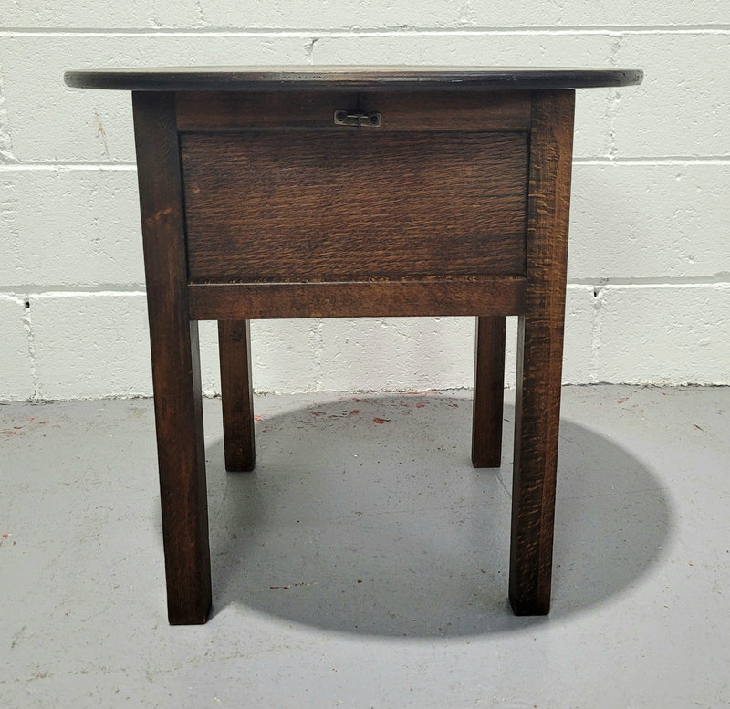 Fabulous round oak side table which also has a hidden sewing box underneath with lovely original blue satin lining and Includes pictured sewing items. It is in good original condition.