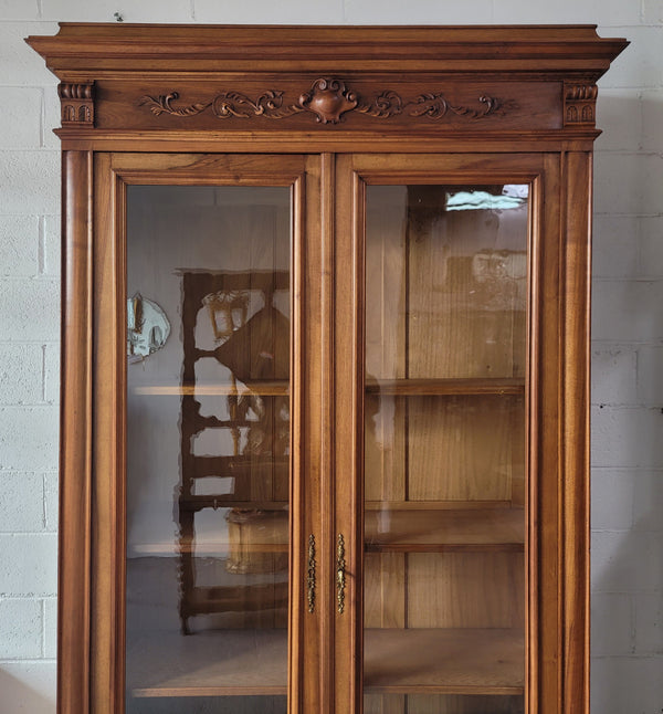 Stunning French Walnut Henry II style two door bookcase with four fully adjustable shelves. The lock on the door is functional and has a key. It is in good original detailed condition.
