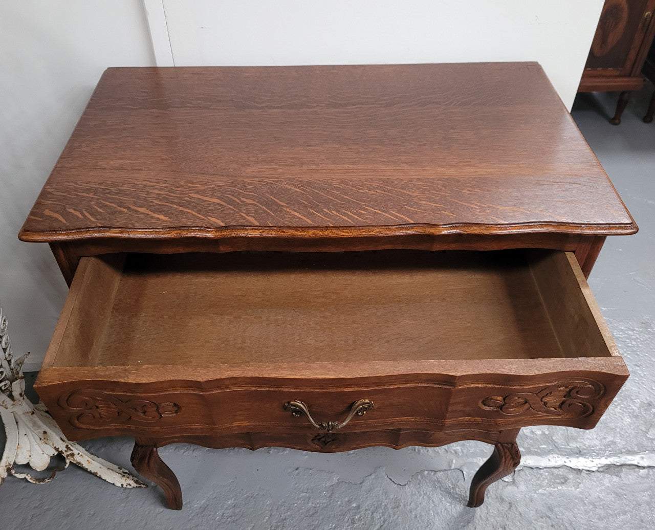 French Oak Louis XV style three drawer commode. It has been sourced from France and has decorative handles and carvings. It is in good original detailed condition.