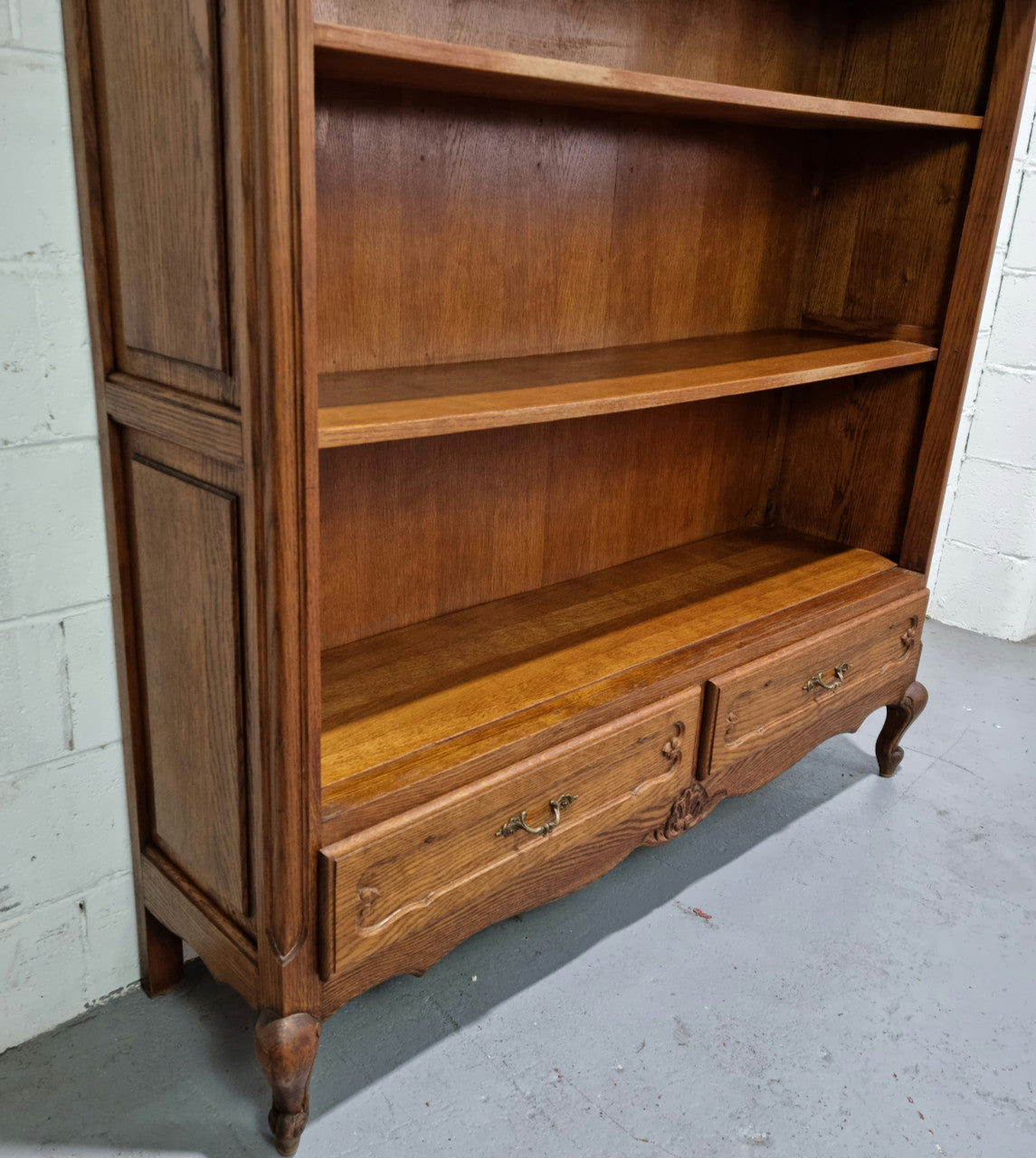 Lovely French Oak Louis XV style open shelf bookcase with two drawers for storage and three shelves in good original detailed condition.