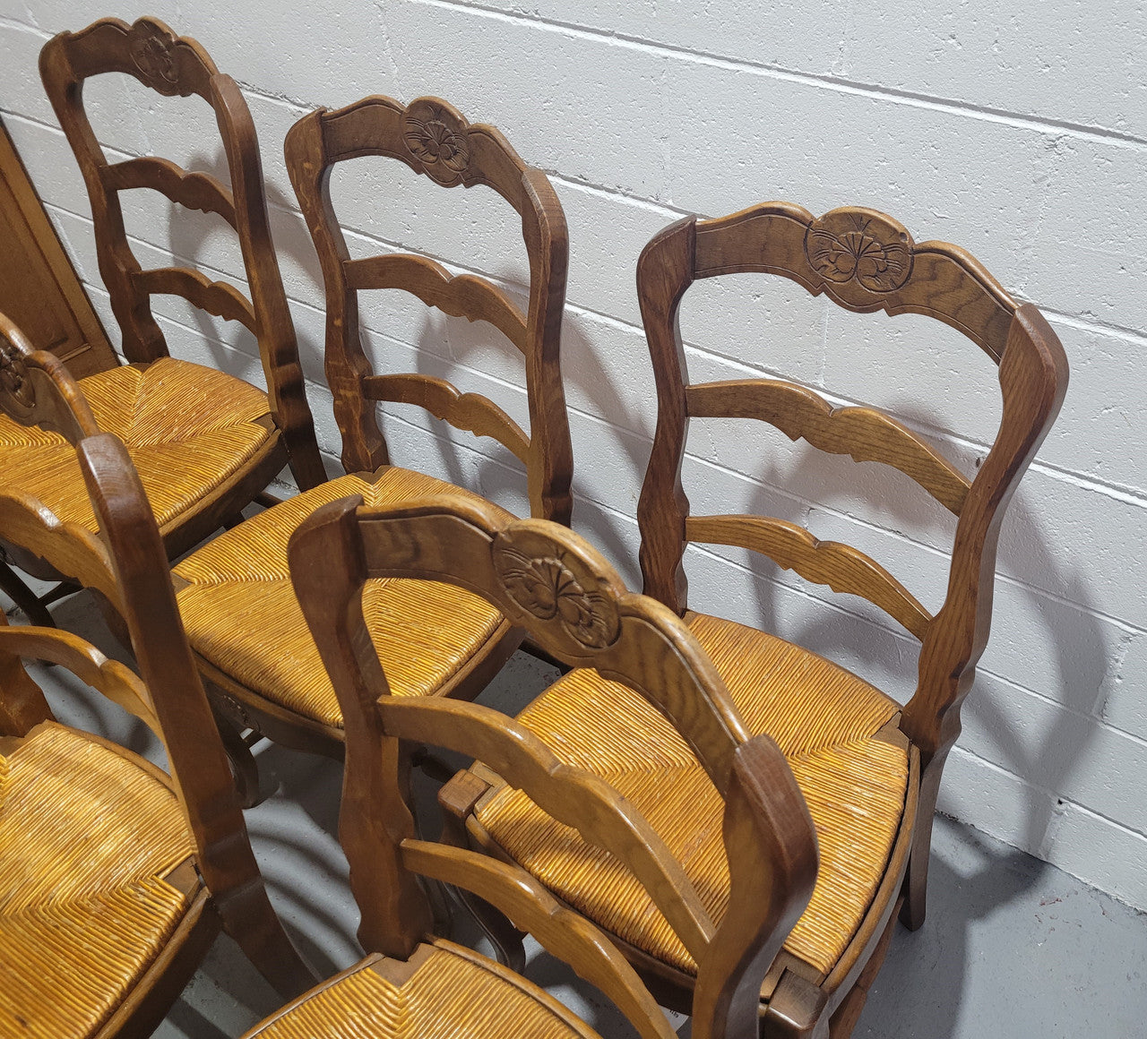 Set of six French Louis 15th style rush seated dining chairs. They are comfortable to sit in and are in original condition.