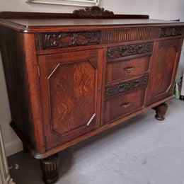 Art Deco Tudor style Oak sideboard with decorative carved detail. Plenty of storage space with two cupboards and four drawers. It has been sourced locally and is in good original detailed condition.