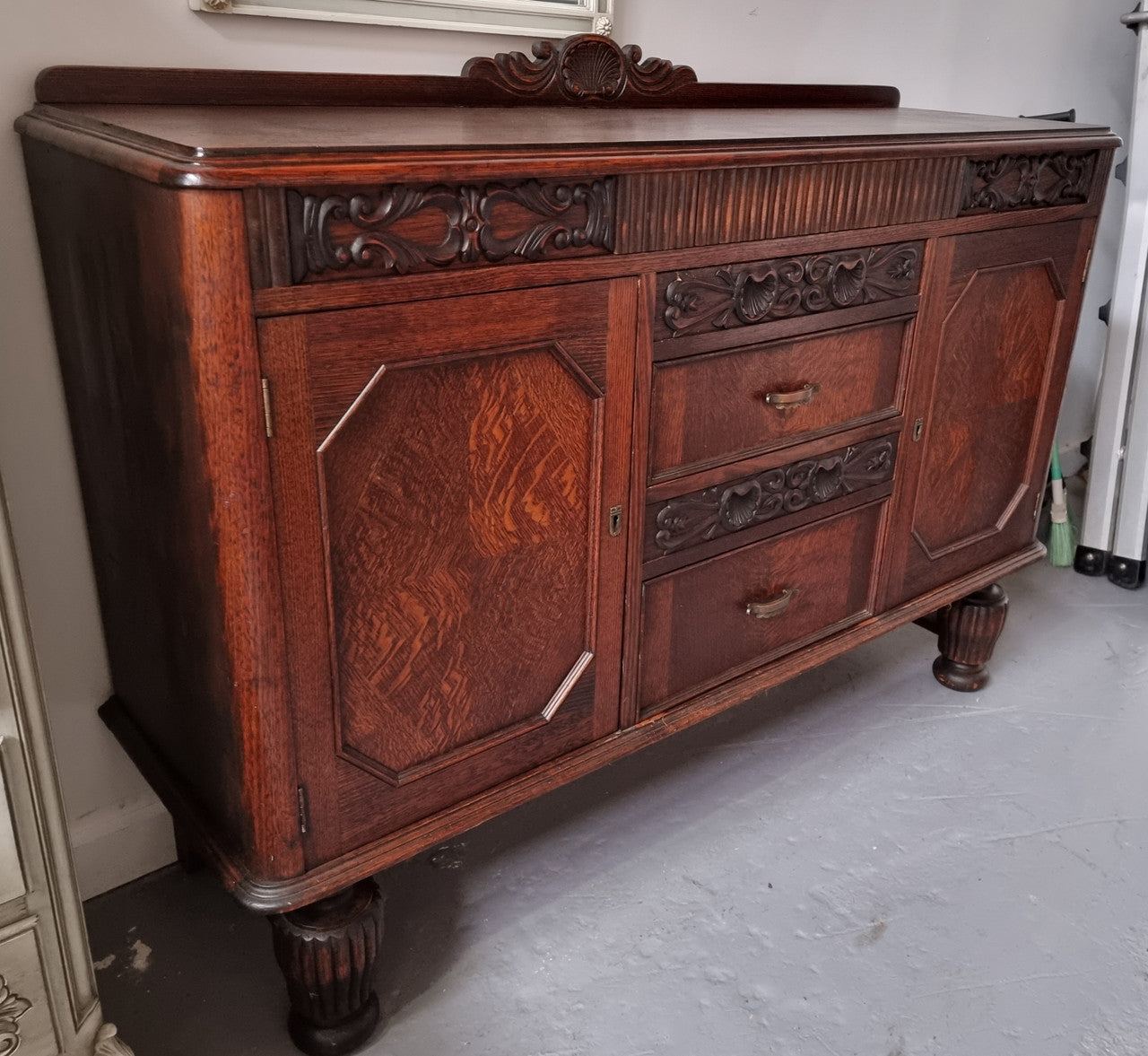 Art Deco Tudor style Oak sideboard with decorative carved detail. Plenty of storage space with two cupboards and four drawers. It has been sourced locally and is in good original detailed condition.