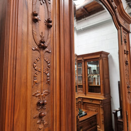 Imposing Louis XV style single mirrored door Walnut armoire. Features deep carved decoration, two interior drawers and three adjustable shelves. It is in good original detailed condition and has been sourced from France.