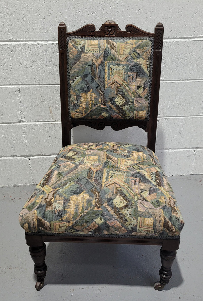 Single upholstered Edwardian nursing chair. Fabric is in good original used condition and chair has four caster wheels and is in good original condition.