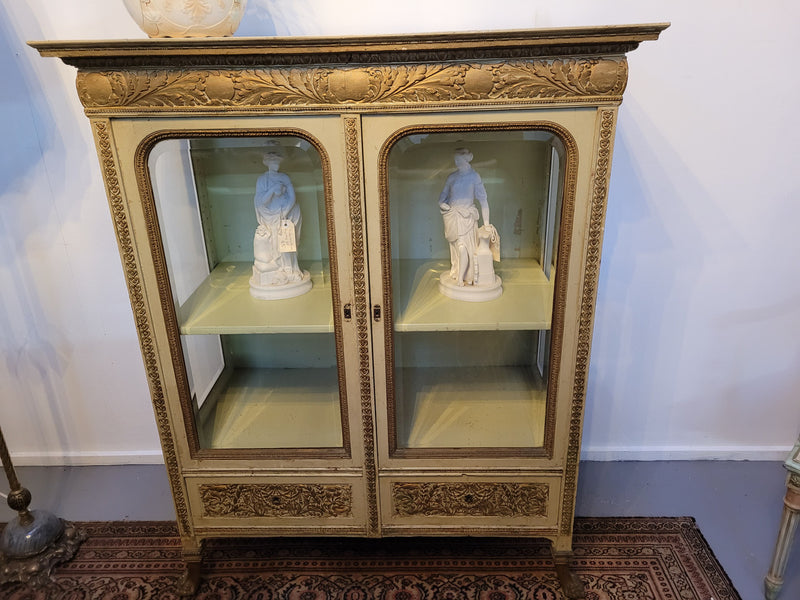 19th Century painted and gilt two door vitrine. Has one adjustable shelf and two drawers. In good original detailed condition.