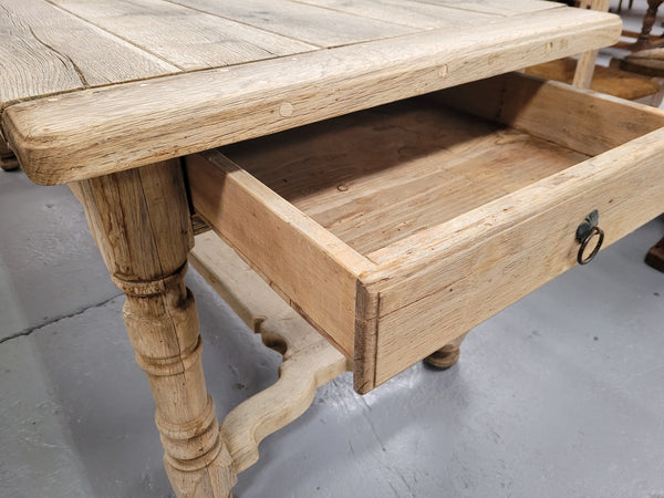 French stripped Oak pedestal stretcher base Farmhouse table with two drawers on either side of table. Features raw wood that could be used as is for a distressed look, or finished and waxed for a more refined look.