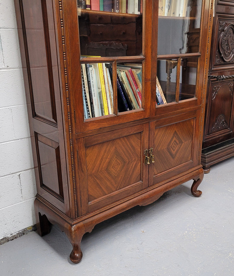 Beautiful four door Walnut bookcase with glass doors. The top section has two fully adjustable shelves and it is of pleasing narrow proportions. It is in good original detailed condition.