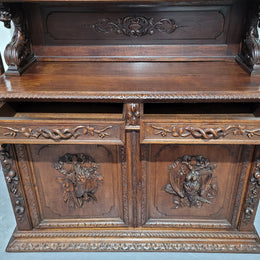 Grand French Oak Gothic style buffet with amazing detailed carvings. This stunning buffet has a display section at the top with two adjustable shelves, two drawers in the middle with elegantly carved handles and storage below with one fixed shelf. It is in good original detailed condition.