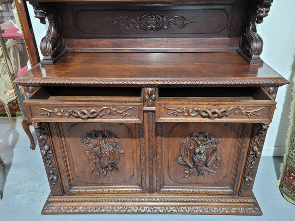 Grand French Oak Gothic style buffet with amazing detailed carvings. This stunning buffet has a display section at the top with two adjustable shelves, two drawers in the middle with elegantly carved handles and storage below with one fixed shelf. It is in good original detailed condition.