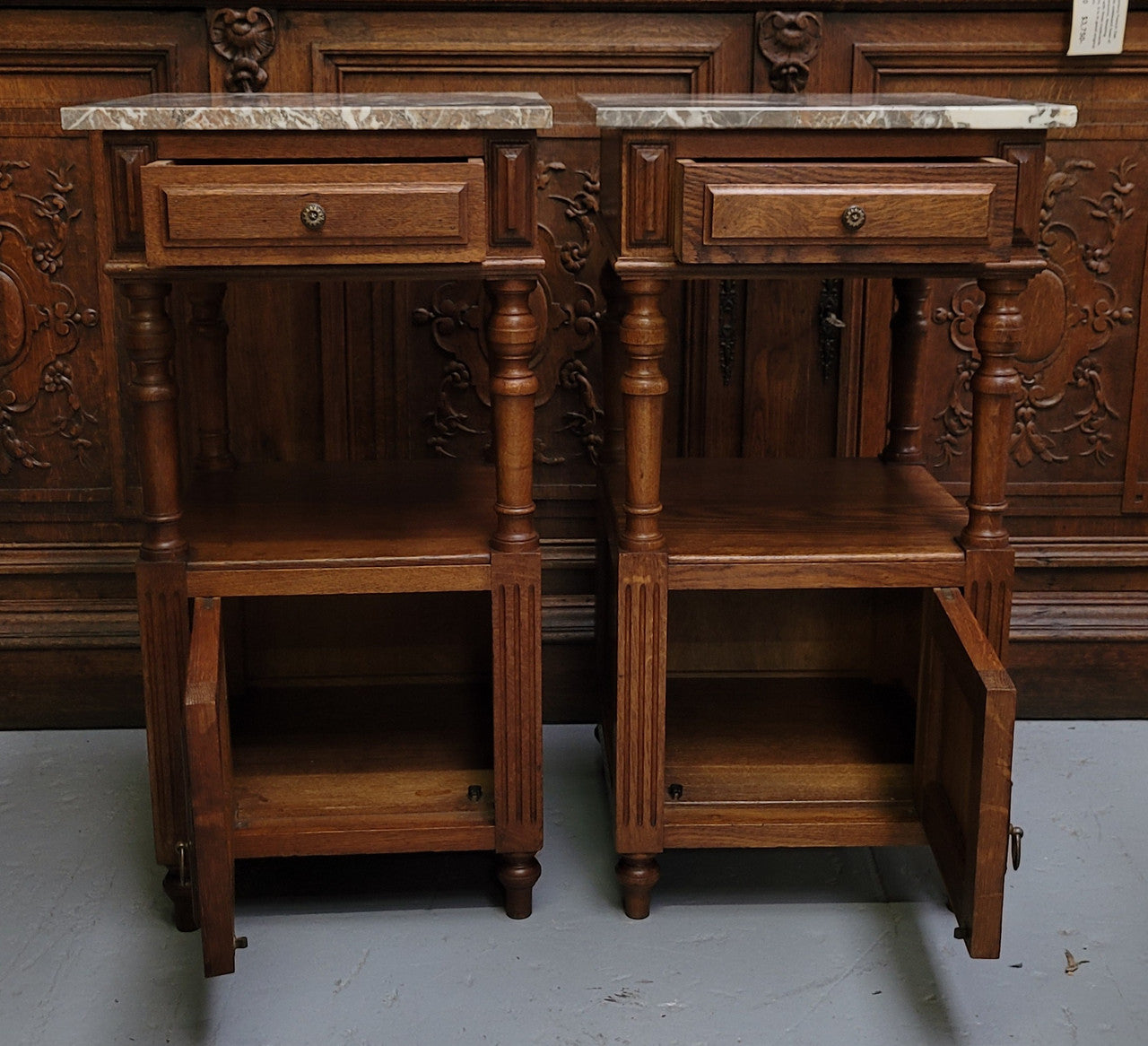 Pair of French Antique Oak marble top bedsides Henry II style. They have a drawer, cupboard and an open shelf for all your storage needs. They have been sourced from France and are in good original detailed condition.