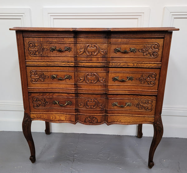 Vintage French dark Oak Louis XV style chest of three drawers. It has beautiful cabriole legs, elegant brass handles and decorative carving throughout. It is in good original detailed condition and has been sourced from France.