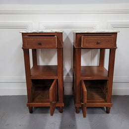 Pair of Antique French Oak Louis XVI style marble top bedside cabinets. They have decorative inlay and have been sourced from France. They are in good original detailed condition.