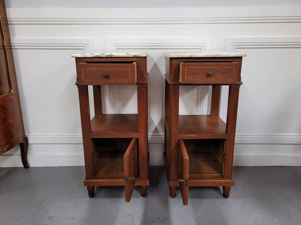 Pair of Antique French Oak Louis XVI style marble top bedside cabinets. They have decorative inlay and have been sourced from France. They are in good original detailed condition.