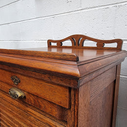 Antique Edwardian roll top Tambour file cabinet desk. This practical antique tambour front filing cabinet dates around 1900 in the Edwardian period and is constructed from Oak. This antique cabinet has an adjustable writing slope, above a tambour front with key and working lock. It has been sourced locally and is in good original detailed condition.