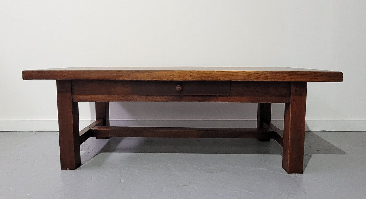 French Farmhouse style heavy Oak coffee table featuring a single drawer. In good original detailed condition.
