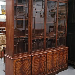 Georgian style Breakfront Flame Mahogany four door bookcase. A very impressive piece with plenty of storage and is of pleasing narrow proportions. It has been sourced locally and is in good original detailed condition.