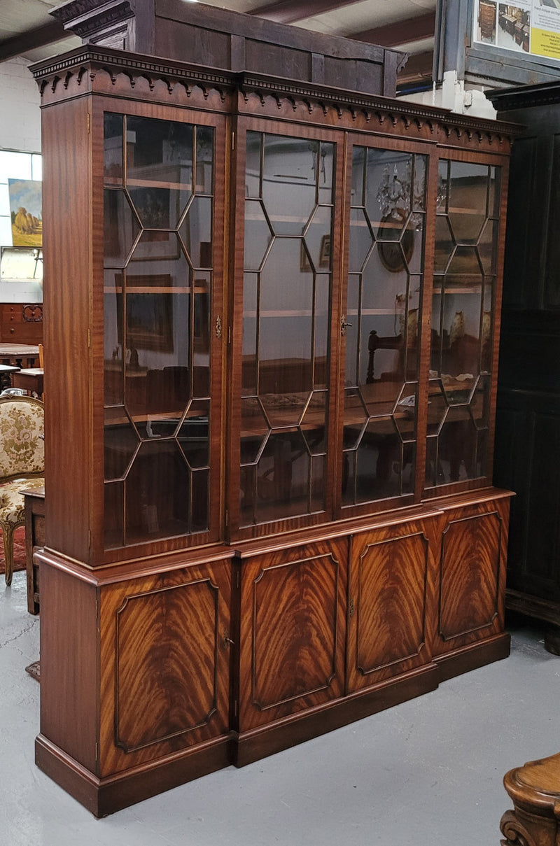 Georgian style Breakfront Flame Mahogany four door bookcase. A very impressive piece with plenty of storage and is of pleasing narrow proportions. It has been sourced locally and is in good original detailed condition.
