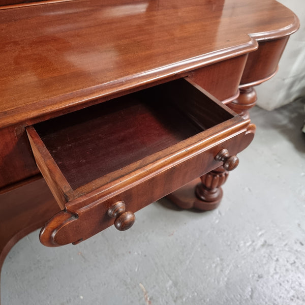 Victorian Mahogany duchess dressing table with tilt mirror on scrolled supports. It has seven trinket drawers and lift up storage. It is in good original condition and has been sourced locally.